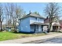 Charming two-story home with a covered porch and well-maintained lawn and light blue siding at 1145 N Belleview Pl, Indianapolis, IN 46222