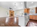 Open concept living room with wood floors and an adjacent modern kitchen at 12527 Saksons Blvd, Fishers, IN 46038