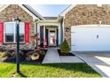 A well-kept home entrance with red shutters, potted plants, and a cozy porch, inviting you to experience the charm at 1371 Blackthorne N Trl, Plainfield, IN 46168