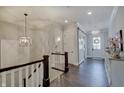 Hallway with staircase and modern light fixtures with dark hardwood floors at 1472 Windpump Way, Carmel, IN 46280