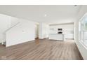 Bright open-concept room featuring hardwood floors and stairs at 1554 N Clearwater Dr, Greenfield, IN 46140