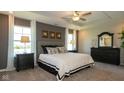 Spacious bedroom features carpet flooring, neutral walls, tray ceiling with fan, large windows and stylish furnishings at 1554 N Clearwater Dr, Greenfield, IN 46140