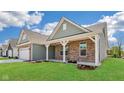 Beautiful home with a covered porch, brick facade, and well-maintained green lawn at 19245 Red Willow Ln, Noblesville, IN 46062