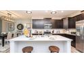 Modern kitchen with sleek black cabinetry, stainless steel appliances, and a large island with a white countertop at 19245 Red Willow Ln, Noblesville, IN 46062