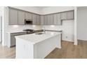 Modern kitchen with gray cabinetry, stainless steel appliances, a white subway tile backsplash and hardwood floors at 19245 Red Willow Ln, Noblesville, IN 46062