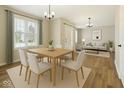Bright dining area with a light wood table and modern chandelier near the entryway and living room at 2236 Willowview Dr, Indianapolis, IN 46239