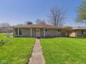 Beautifully maintained ranch home with stone exterior, walkway, and lush lawn at 2329 E 8Th St, Anderson, IN 46012
