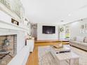 Inviting living room featuring a painted brick fireplace, hardwood floors, and neutral decor at 2329 E 8Th St, Anderson, IN 46012