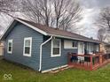 Side view of the inviting home featuring a well-maintained yard and a charming wooden deck at 2517 Horton Dr, Anderson, IN 46011