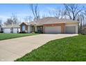 Expansive driveway leads to a well-maintained brick home with a two-car attached garage and manicured lawn at 267 Westbrook Ct, Columbus, IN 47201