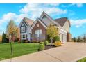 Well-maintained two-story home with attached garage and landscaped front yard at 3728 Dunellen Cir, Carmel, IN 46074
