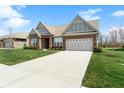 Beautiful home with a long driveway and two-car garage, set against a backdrop of mature trees and blue sky at 3971 Albert Ln, Bargersville, IN 46106
