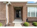 A welcoming entryway to this brick home with a decorative wreath on the door and lush landscaping at 3971 Albert Ln, Bargersville, IN 46106