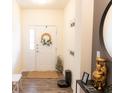 Inviting entryway with stylish decor, a bright white door, and wood-look flooring at 5301 Tanglewood Ln, Whitestown, IN 46075