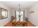 Elegant dining room featuring wood floors, a long wooden table, and a modern light fixture at 6018 Maple Forge Cir, Indianapolis, IN 46254