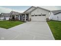 Long concrete driveway leading up to a two-car garage on a home with green lawn at 714 Faudree Dr, Westfield, IN 46074