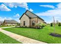 Home exterior featuring green lawn, blooming trees, and a sidewalk leading to the entrance at 725 Meadowbrook Ln, Franklin, IN 46131
