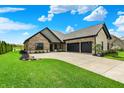 Well-maintained home with manicured lawn, black mulch beds, and a three-car garage at 725 Meadowbrook Ln, Franklin, IN 46131