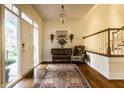 Elegant foyer featuring hardwood floors, a decorative rug, a wooden staircase, and stylish accent furniture at 8037 Lynch Ln, Indianapolis, IN 46250