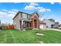 Well-maintained lawn with a charming two-story home, featuring brick accents, a three-car garage, and mature landscaping at 8734 Blue Marlin Dr, Indianapolis, IN 46239