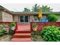 A cozy outdoor deck with flowers, chairs, and umbrella at 1000 Janet Dr, Greenwood, IN 46142