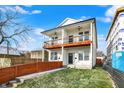 View of a modern duplex with a well-maintained lawn, wooden fence, and inviting double balconies at 1018 Calvary St, Indianapolis, IN 46203