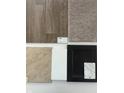 Selection of interior materials and finishes with wood and carpet flooring, marble countertop and black cabinet at 1056 Stubble Run, Danville, IN 46122