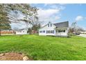 Exterior view of home with large lawn, mature trees and landscaping, including detached garage at 121 Illinois St, Shirley, IN 47384