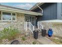 Home's entrance featuring a stone facade, a decorative door, and potted plants creating a welcoming entry at 12166 N Bray Rd, Mooresville, IN 46158