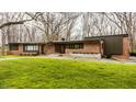 Charming single-story brick home featuring a well-maintained lawn and mature trees, offering curb appeal at 123 W 81St St, Indianapolis, IN 46260