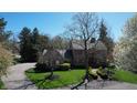 Stunning two-story home with red shutters, mature trees, and a circular driveway at 13599 Brentwood Ln, Carmel, IN 46033