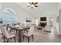 Bright, staged dining and living space boasts vaulted ceilings, a fireplace, and ample natural light from large windows at 13847 Wabash Dr, Fishers, IN 46038
