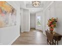 Bright hallway features wood flooring, elegant light fixture, and a view of the front door at 16422 Brigham Ln, Westfield, IN 46074