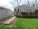 Relaxing backyard featuring a wooden deck, walkway, and well-manicured lawn at 2012 N Janney Ave, Muncie, IN 47304