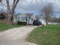 Inviting single-Gathering home with a gravel driveway leading to a detached garage and well-maintained lawn at 2012 N Janney Ave, Muncie, IN 47304