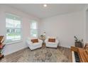 Bright living room featuring wood floors, piano, two armchairs, and natural light at 2208 Dudley Ave, Westfield, IN 46074