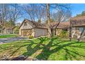 Attractive home with stone accents, a two-car garage, and a well-kept lawn with mature shade trees at 2214 Van Ness Pl, Indianapolis, IN 46240