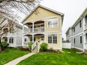 Two-story home with a charming yellow exterior and double porches at 2316 N Pennsylvania St # 1, Indianapolis, IN 46205