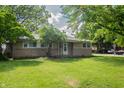 Ranch-style home with a well-kept lawn and mature shade trees in a suburban setting at 3140 Bonham Dr, Indianapolis, IN 46222