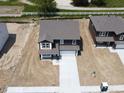 Aerial view of two-story house with gray roof and white garage door on a construction lot with a light-colored driveway at 3315 Godby Dr, Sheridan, IN 46069