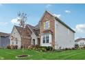 Charming home featuring brick and stone accents, complemented by a well-manicured lawn and garden at 3665 Conifer Dr, Zionsville, IN 46077