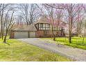 Traditional home with an attached garage and a spacious driveway, surrounded by greenery and mature trees at 3753 Whippoorwill Lake S Dr, Monrovia, IN 46157