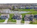 Aerial view of a brick home next to a pond surrounded by well-maintained lawns and trees at 419 Dovetree Dr, Danville, IN 46122