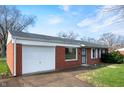 A brick house with a well-maintained lawn, a white garage door and white trim at 4829 W 37Th St, Indianapolis, IN 46224