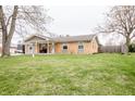 A well-maintained single-story home with a brick facade, a welcoming front porch, and a lush green lawn at 504 W Dwain, Shelbyville, IN 46176