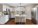 Well-lit kitchen with stainless steel appliances, quartz countertops, island, and modern light fixtures at 518 Carthage Cir, Westfield, IN 46074
