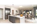 Modern kitchen with stainless steel appliances, gray cabinets, and a large island at 5692 Coulter Way, Greenwood, IN 46143
