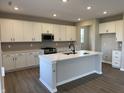 Spacious kitchen with white cabinets, a large island, stainless appliances, and hardwood floors at 5692 Coulter Way, Greenwood, IN 46143