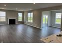 Open-concept living room with a fireplace, hardwood floors, and bright windows overlooking the backyard at 5692 Coulter Way, Greenwood, IN 46143