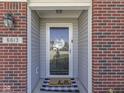 Close-up of the front entrance featuring a stylish front door, sidelights, and a welcome mat at 6613 Harvest Ridge Ct, Indianapolis, IN 46237